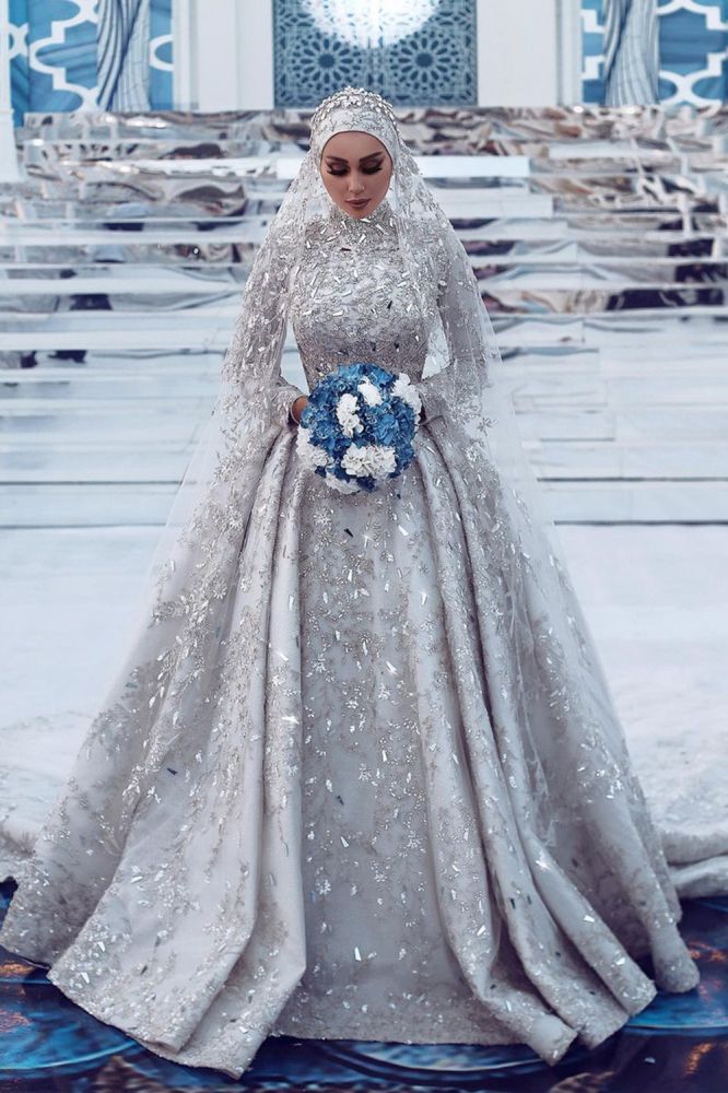 Robe de mariée somptueuse à sequins, manches longues, col montant et traîne.