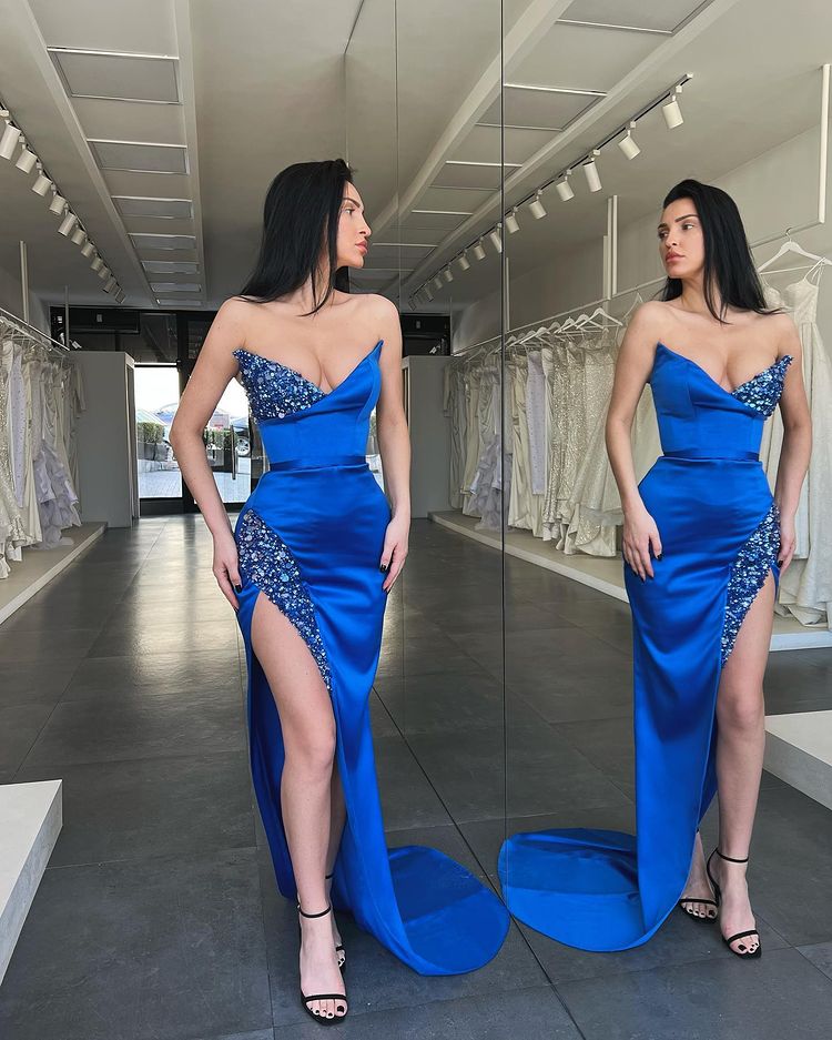 Magnifique robe de soirée longue sans manches bleu roi, ornée de perles et fendue.