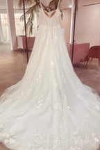 Precioso vestido de novia de tul, corte A, sin mangas, con tirantes finos, largo hasta el suelo y cola de corte. 