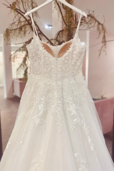 Precioso vestido de novia de tul, corte A, sin mangas, con tirantes finos, largo hasta el suelo y cola de corte. 