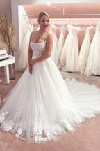 Precioso vestido de novia de tul, corte A, sin mangas, con tirantes finos, largo hasta el suelo y cola de corte. 