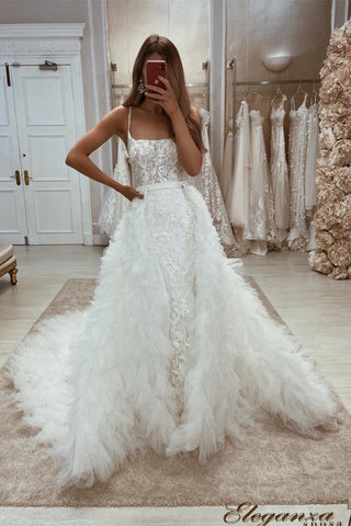 Precioso vestido de novia de corte A, sin mangas, con tirantes finos, apliques de encaje y cola desmontable.