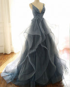Magnifique robe de bal bleu foncé à fines bretelles et décolleté en V, ornée de volants.