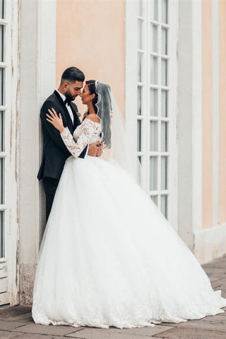 Precioso vestido de novia blanco de corte princesa con encaje, manga larga y tul floral. 