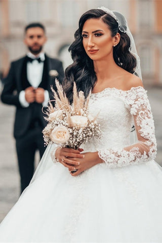 Precioso vestido de novia blanco de corte princesa con encaje, manga larga y tul floral. 