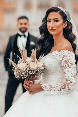 Precioso vestido de novia blanco de corte princesa con encaje, manga larga y tul floral. 
