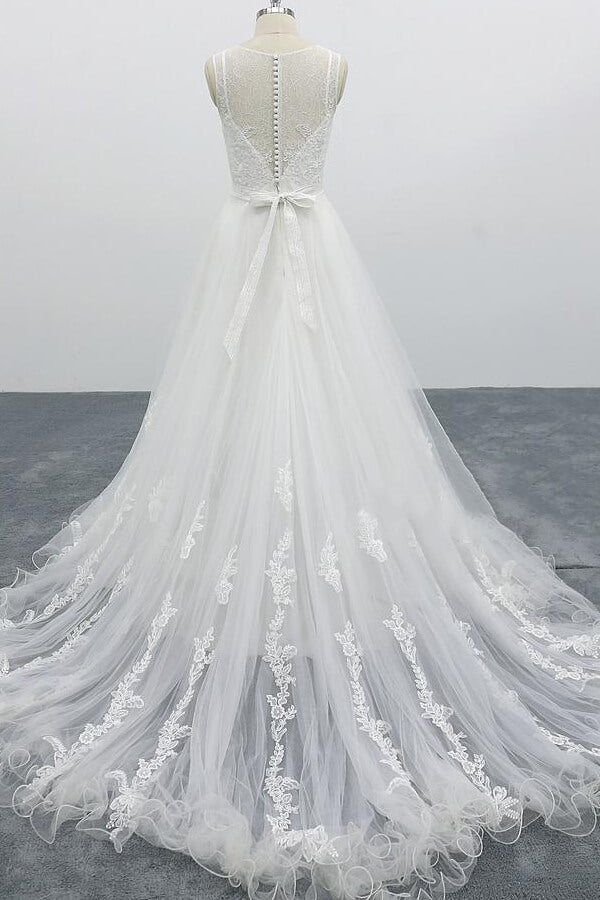 Robe de mariée longue et élégante en tulle dos nu, coupe trapèze et ornée d'appliqués.