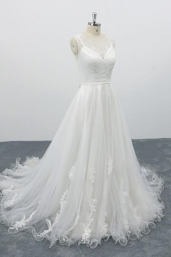 Robe de mariée longue et élégante en tulle dos nu, coupe trapèze et ornée d'appliqués.