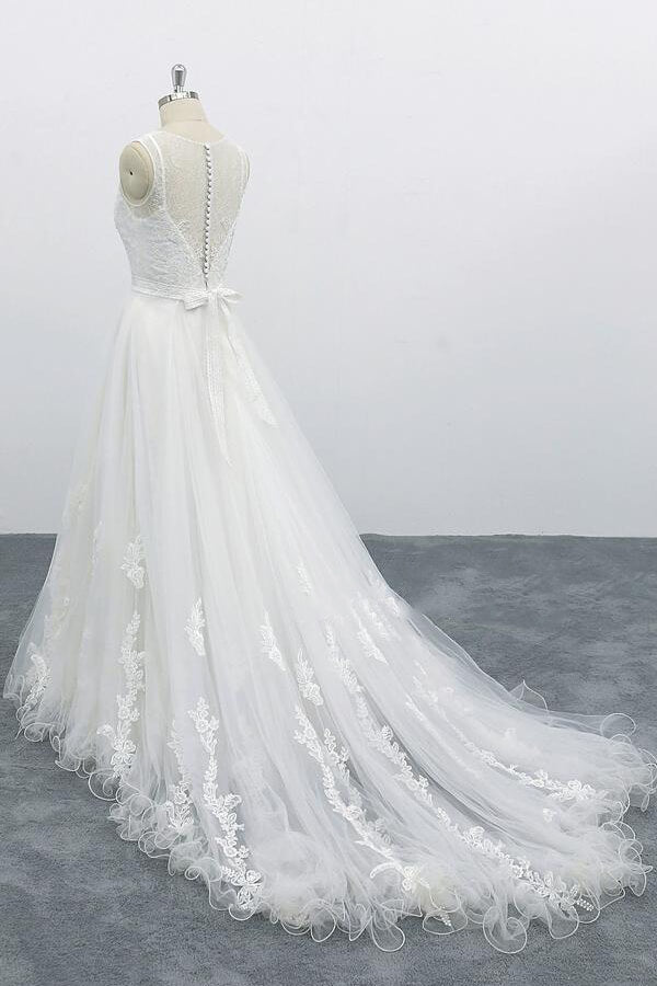 Robe de mariée longue et élégante en tulle dos nu, coupe trapèze et ornée d'appliqués.