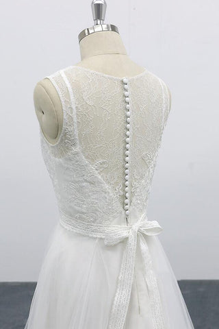 Robe de mariée longue et élégante en tulle dos nu, coupe trapèze et ornée d'appliqués.