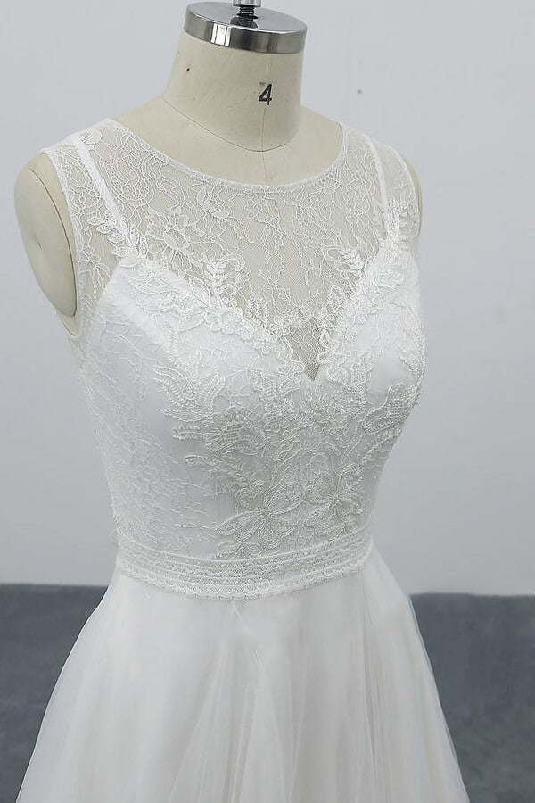 Robe de mariée longue et élégante en tulle dos nu, coupe trapèze et ornée d'appliqués.
