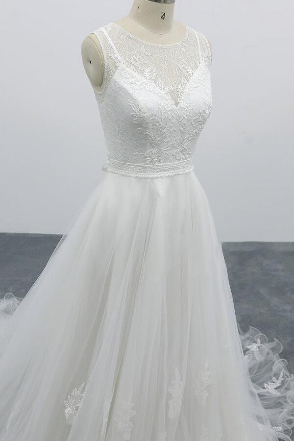 Robe de mariée longue et élégante en tulle dos nu, coupe trapèze et ornée d'appliqués.