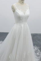 Robe de mariée longue et élégante en tulle dos nu, coupe trapèze et ornée d'appliqués.