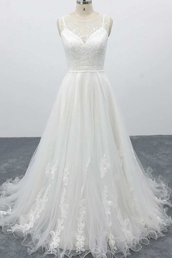 Robe de mariée longue et élégante en tulle dos nu, coupe trapèze et ornée d'appliqués.