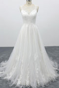 Robe de mariée longue et élégante en tulle dos nu, coupe trapèze et ornée d'appliqués.