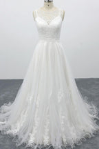 Robe de mariée longue et élégante en tulle dos nu, coupe trapèze et ornée d'appliqués.