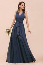 Vestido gris de dama de honor con abertura lateral, escote en V, sin mangas y largo hasta el suelo para la novia