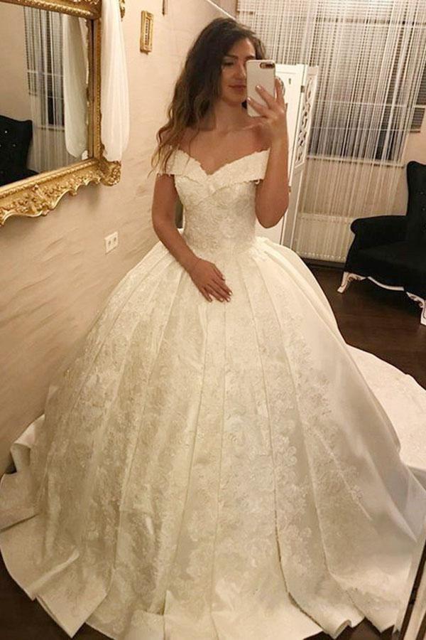 Robe de mariée longue ivoire à épaules dénudées, ornée d'appliqués de dentelle et de satin.
