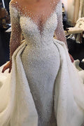 Robe de mariée ivoire à manches longues, traîne amovible, col en V, boutons et entièrement recouverte de perles 