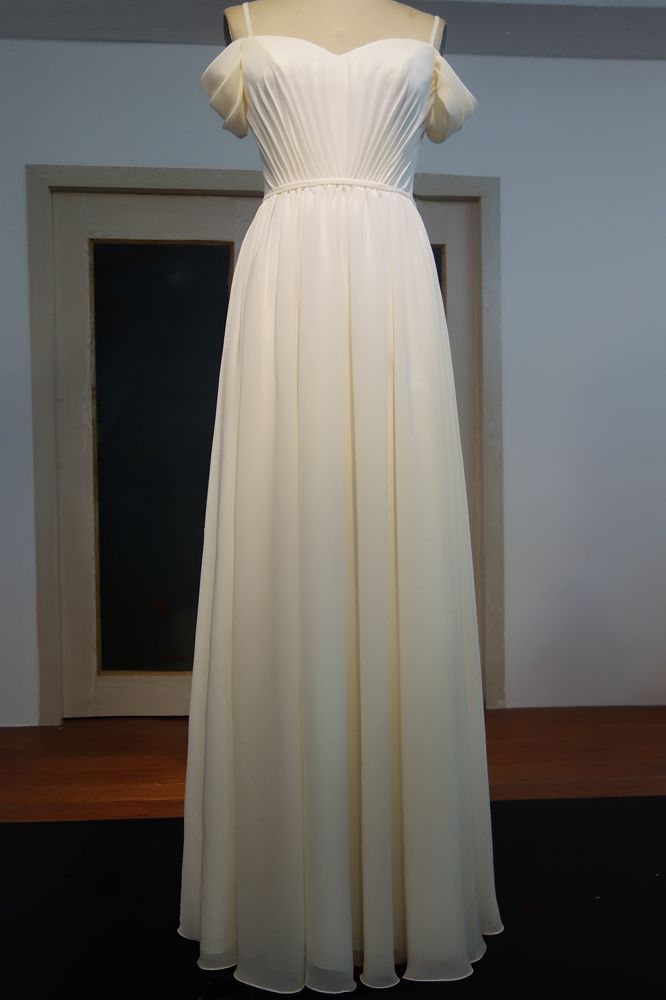 Robe de bal en mousseline ivoire à bretelles spaghetti, décolleté cœur et ourlet trapèze, longueur au sol, volants, ourlet spaghetti.