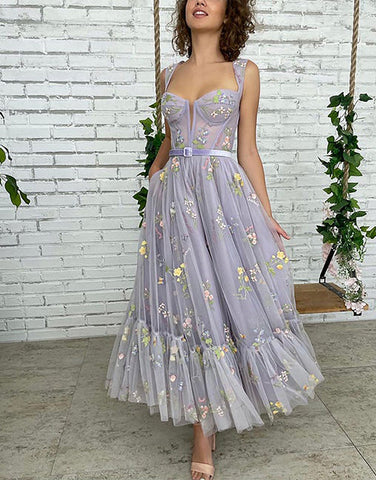 Vestido de fiesta de tul color lila, corte en A y largo hasta la rodilla, con bordados.