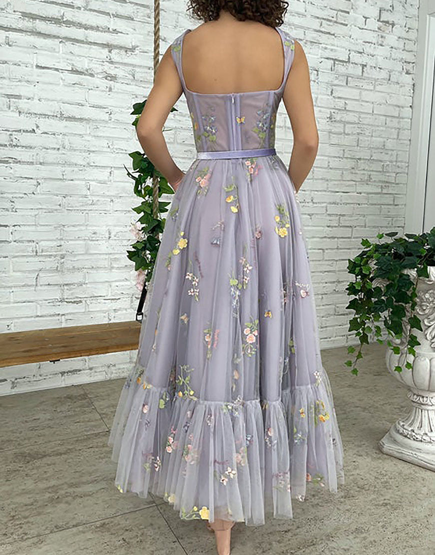 Vestido de fiesta de tul color lila, corte en A y largo hasta la rodilla, con bordados.