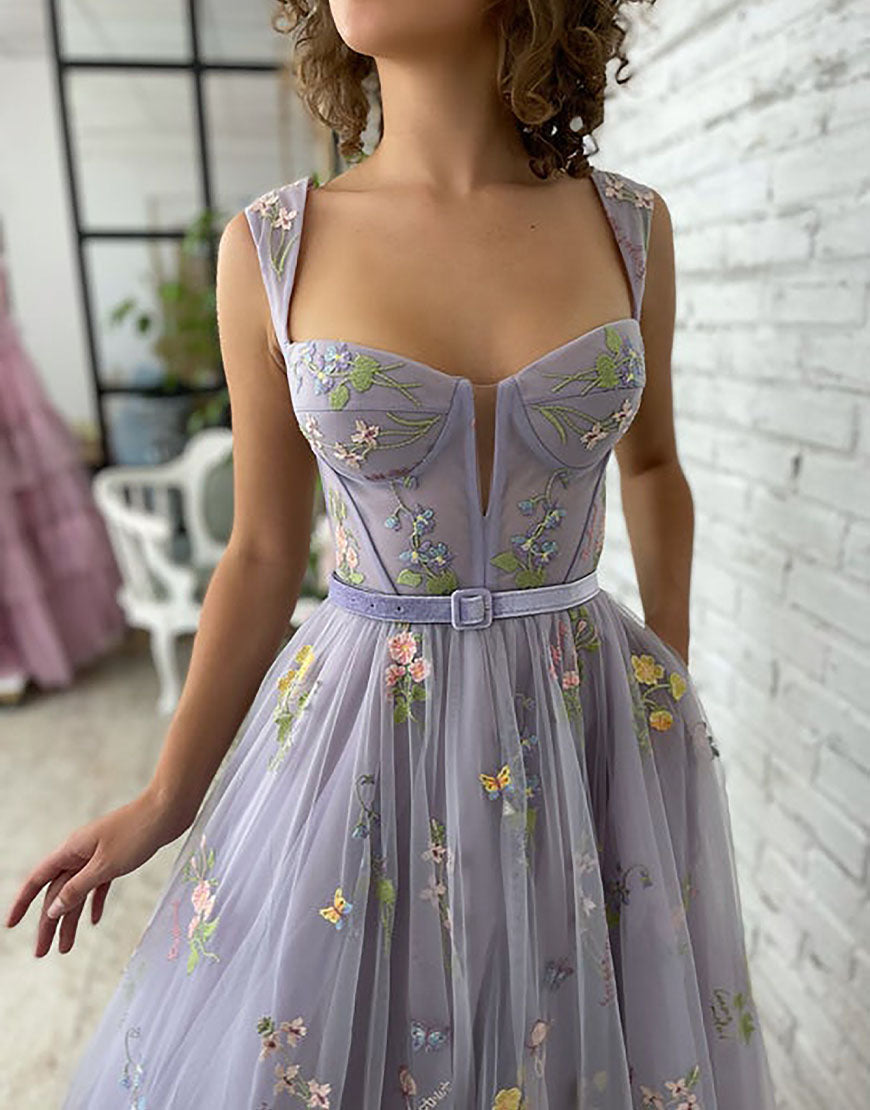 Vestido de fiesta de tul color lila, corte en A y largo hasta la rodilla, con bordados.