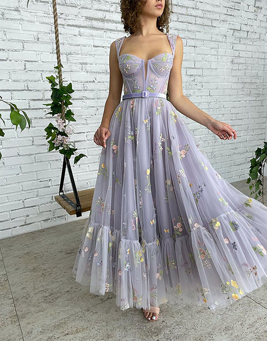 Vestido de fiesta de tul color lila, corte en A y largo hasta la rodilla, con bordados.