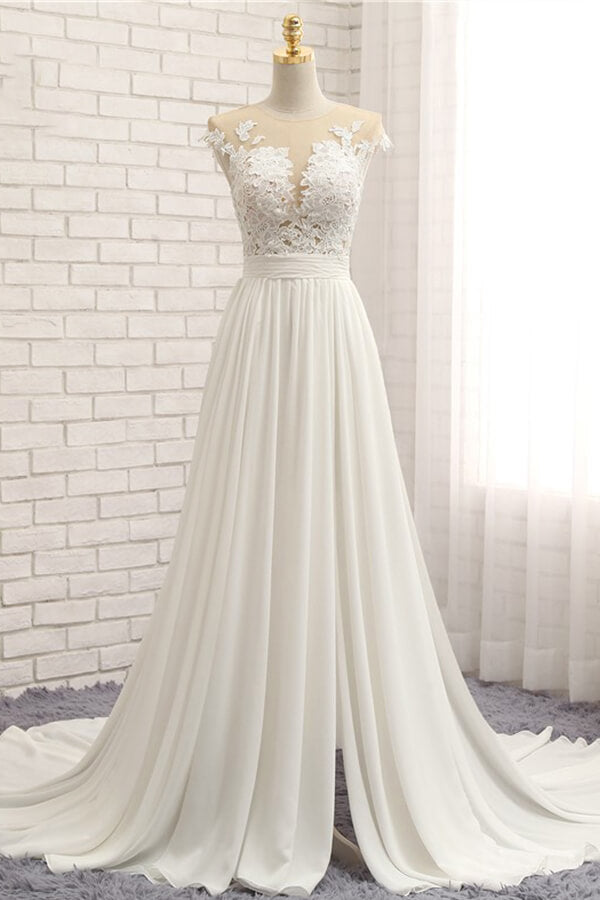 Robe de mariée longue en mousseline de soie ornée d'appliqués de dentelle et fendue, coupe trapèze.