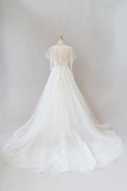 Robe de mariée longue en tulle et dentelle à manches, coupe trapèze, ornée d'appliqués.