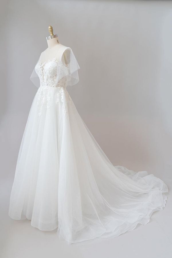 Robe de mariée longue en tulle et dentelle à manches, coupe trapèze, ornée d'appliqués.
