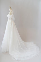 Robe de mariée longue en tulle et dentelle à manches, coupe trapèze, ornée d'appliqués.