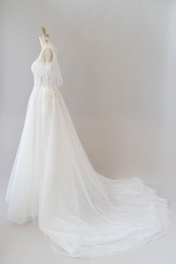 Robe de mariée longue en tulle et dentelle à manches, coupe trapèze, ornée d'appliqués.