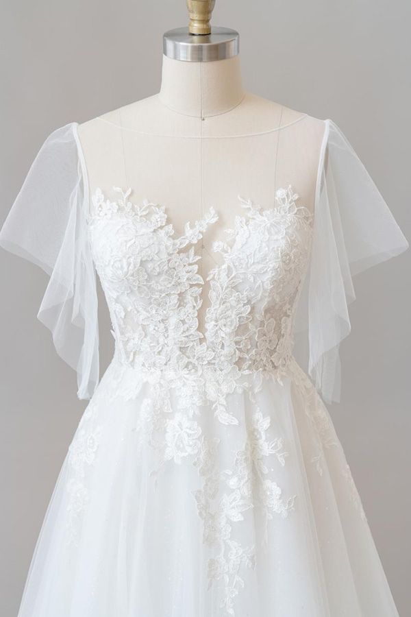 Robe de mariée longue en tulle et dentelle à manches, coupe trapèze, ornée d'appliqués.