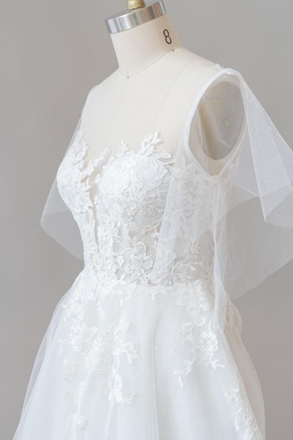 Robe de mariée longue en tulle et dentelle à manches, coupe trapèze, ornée d'appliqués.
