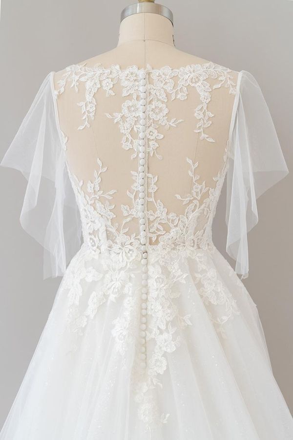 Robe de mariée longue en tulle et dentelle à manches, coupe trapèze, ornée d'appliqués.