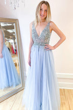 Robe de bal longue trapèze en tulle à décolleté en V profond et dos nu fendu, ornée de perles et fendue.