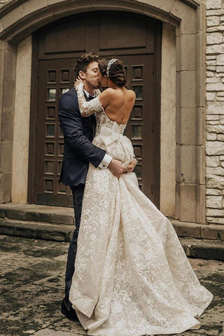 Vestido de novia largo de encaje con corte en A, hombros descubiertos y mangas, estilo línea A.