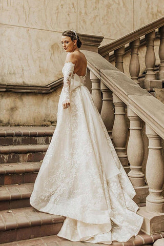 Vestido de novia largo de encaje con corte en A, hombros descubiertos y mangas, estilo línea A.