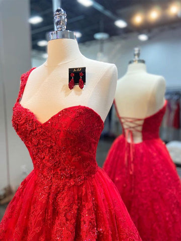 Robe de bal rouge dos nu en tulle et dentelle, longue, asymétrique, à une épaule.
