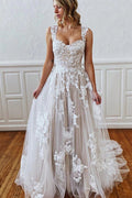 Vestido de novia de corte sirena con tirantes largos, escote corazón, apliques de encaje y tul sin espalda.