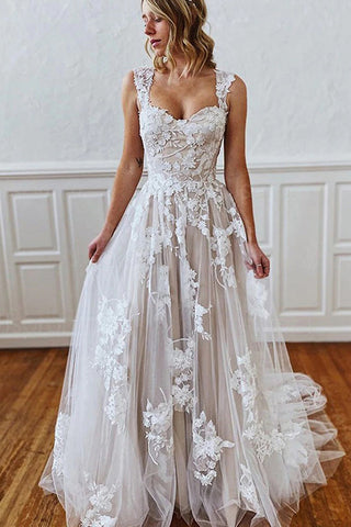 Vestido de novia de corte sirena con tirantes largos, escote corazón, apliques de encaje y tul sin espalda.