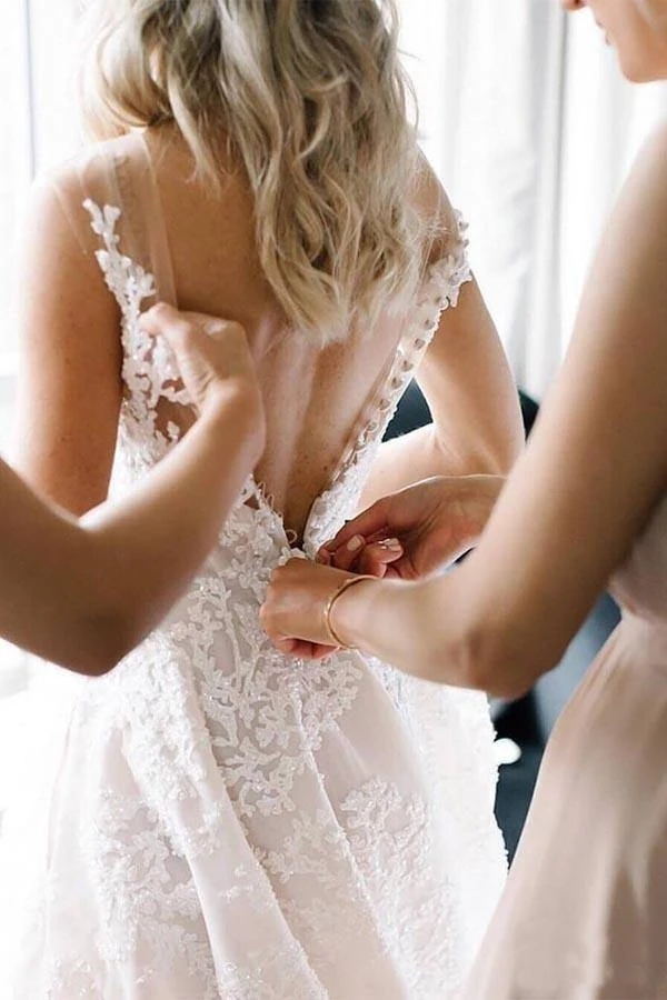 Vestido de novia de corte sirena con tirantes largos, escote en V, cuentas florales, tul y espalda descubierta.