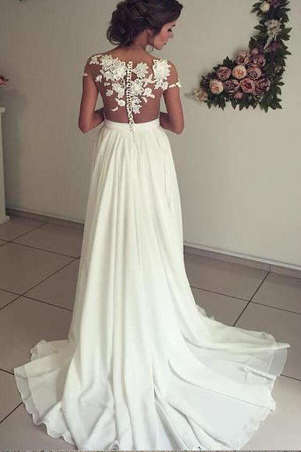 Robe de mariée longue en mousseline de soie ornée d'appliqués de dentelle et d'un décolleté en cœur, avec fente, coupe trapèze et décolleté cœur.