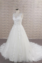 Robe de mariée longue en tulle et dentelle appliquée, décolleté en cœur, coupe trapèze
