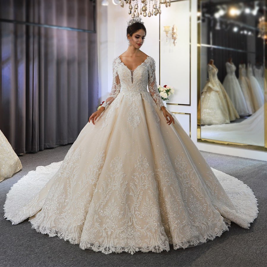 Vestido de novia largo de corte A, escote corazón, espalda descubierta, apliques de encaje y lentejuelas, con mangas.
