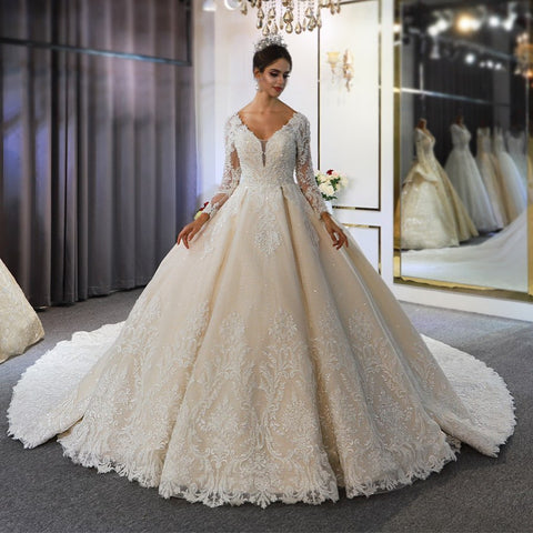 Vestido de novia largo de corte A, escote corazón, espalda descubierta, apliques de encaje y lentejuelas, con mangas.