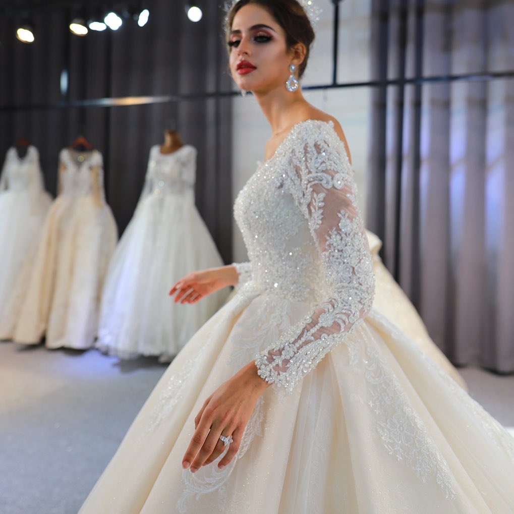 Vestido de novia largo de corte A, escote corazón, espalda descubierta, apliques de encaje y lentejuelas, con mangas.