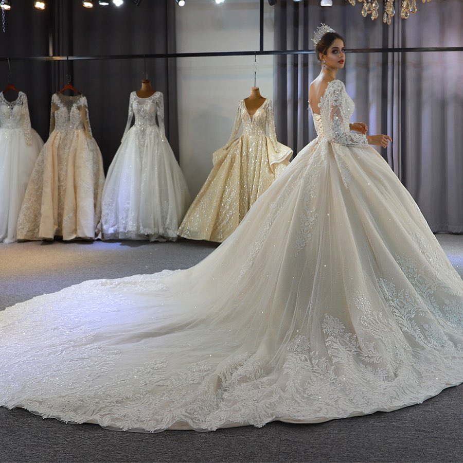 Vestido de novia largo de corte A, escote corazón, espalda descubierta, apliques de encaje y lentejuelas, con mangas.