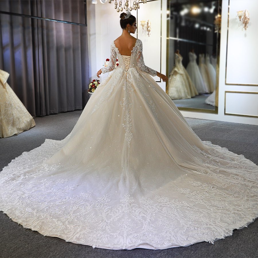 Vestido de novia largo de corte A, escote corazón, espalda descubierta, apliques de encaje y lentejuelas, con mangas.